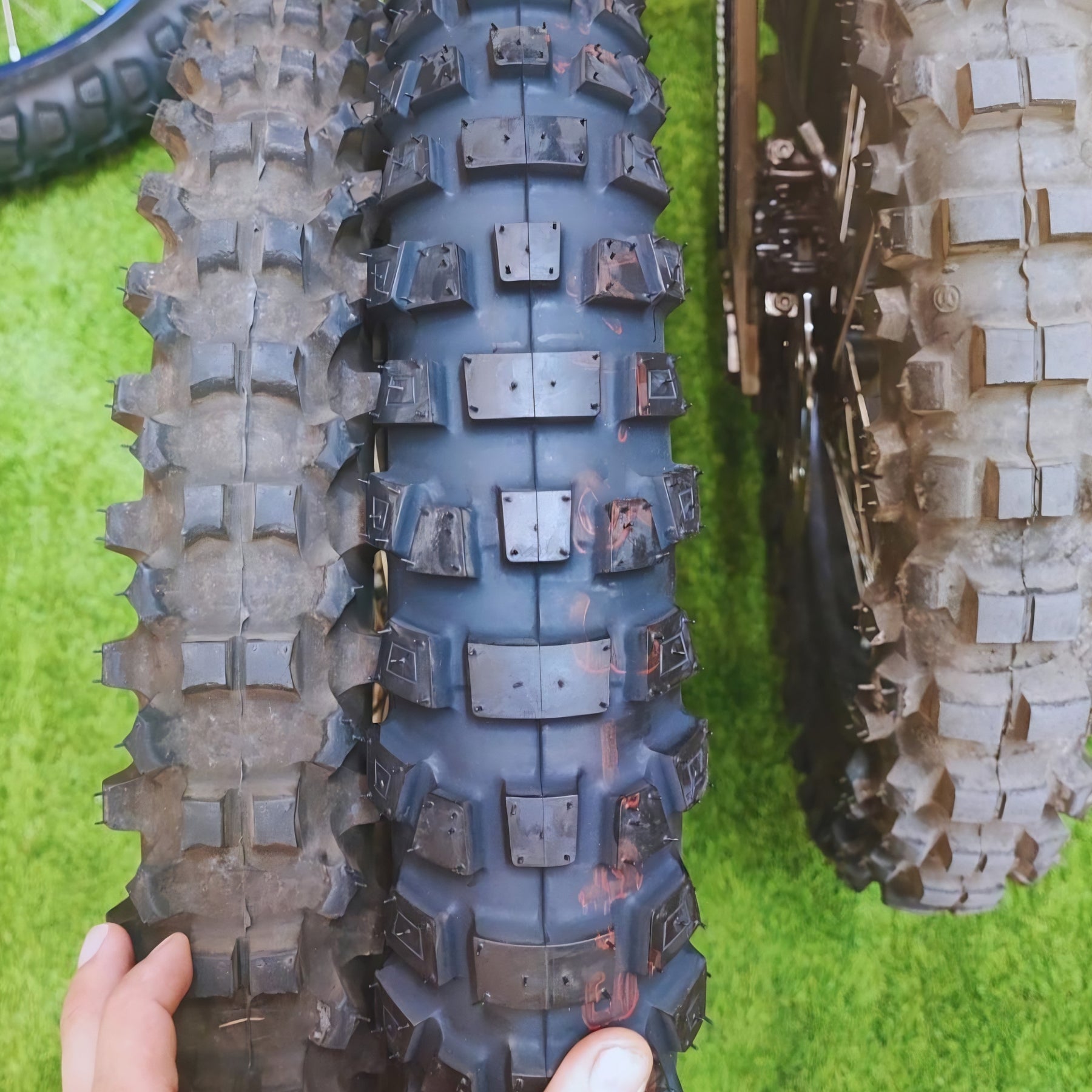 Neumático Bridgestone 90/100-19 para off-road y on-road, montado en motocicleta, con banda de rodadura adecuada para terrenos variados.
