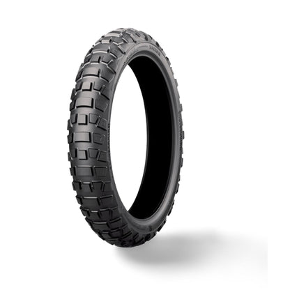 Neumático Bridgestone 90/100-19 para off-road y on-road, con dibujo de banda de rodadura y marca X-EMOTOS en entorno outdoor